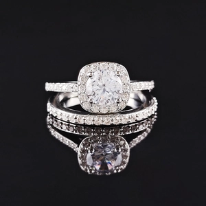 Conjunto de anillos de boda de lujo con circonita de corte cojín sobre fondo negro