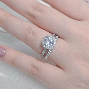 Detalle del conjunto de anillos de novia de doble banda con circonita redonda tipo halo