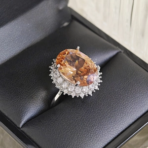 Champagne oval gemstone cocktail ring with diamond halo in a luxury jewelry box
