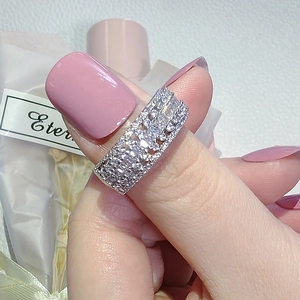 Squisito anello largo traforato placcato argento con file multiple di zirconi su un dito femminile