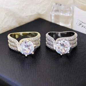 Dettaglio macro di anelli classici a sei griffe con pavé in finitura argento e oro