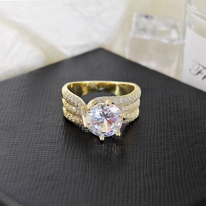 Dettaglio dell'anello di lusso dorato a sei griffe con pavé di diamanti su scatola di pelle