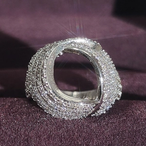 Vue macro d'une bague spirale argentée avec cristaux pavés sur fond de velours violet