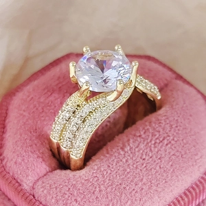 Dettaglio macro di un anello d'oro di lusso con pietra rotonda e pavé di diamanti