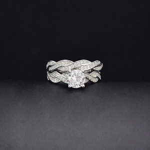 Macro shot of twisted silver ring set with round brilliant cut center stone and pavé diamonds