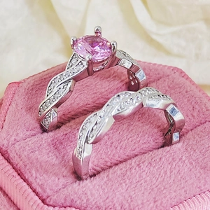 Macro detail of silver ring set with pink round gemstone in pink velvet gift box