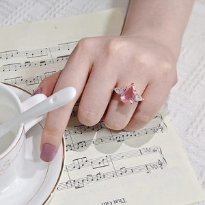 Vue détaillée d'une bague rose taille poire avec anneau en or rose sur main