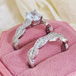 Macro shot of silver wedding ring set with twisted diamond band in pink velvet jewelry box