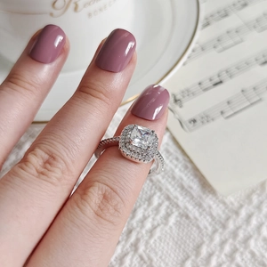 Détail de la bague avec pierre de taille coussin et sertissage double halo en diamants