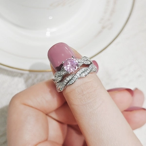 Close-up of a double-layer ring set with pink round-cut gemstone and pavé zircon details