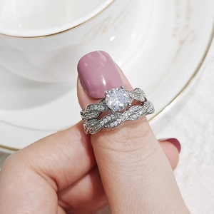 Macro shot of silver-toned stacked rings with round-cut stones and twisted bands