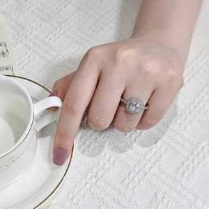 Détail de bague en zircon carré avec double halo et pavé porté au doigt