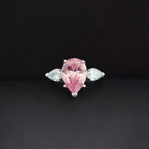 Bague élégante en argent avec pierre centrale rose poire et gemmes blanches sur fond noir