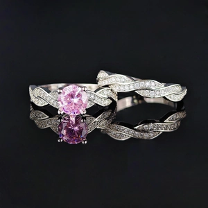 Elegant silver ring set with pink round-cut gemstone and micro-pave twisted bands