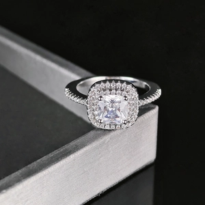 Bague luxueuse en argent avec zircon carré, double halo et anneau pavé sur présentoir noir