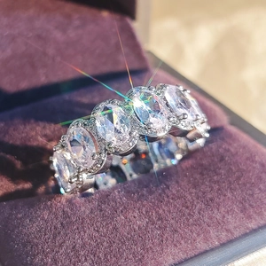 Macro shot of silver halo ring with oval-cut crystals in a purple velvet jewelry box