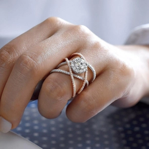 Dettaglio dell'anello incrociato con grande diamante e cristalli pavé indossato sulla mano