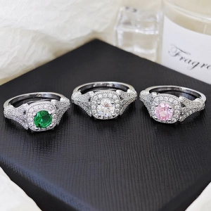 Detalle de anillos de plata con piedras de circonita halo cuadradas en verde, blanco y rosa