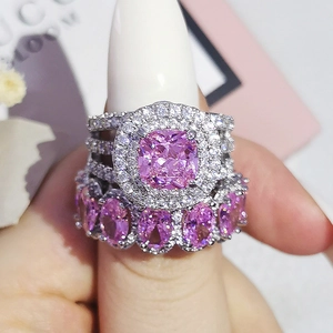 Detailed view of cushion-cut pink gemstone ring set with sparkling zircon pavé in white gold
