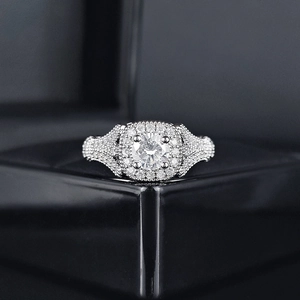 Primer plano de un anillo plateado con circón estilo halo en caja de joyería negra