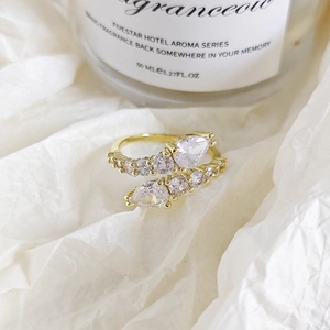 Macro shot of gold wrap ring featuring pear-cut zircon stones and pavé accents