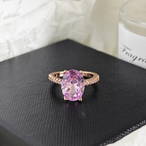 Primer plano de un anillo de oro rosa con gema rosa ovalada y pequeños diamantes