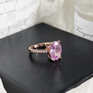 Vista macro de anillo en oro rosa con gema rosa ovalada y circonitas blancas laterales