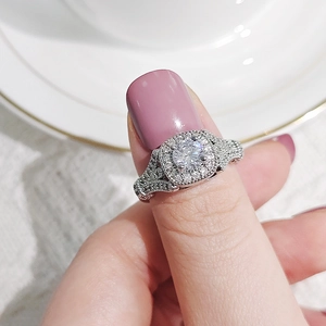 Primer plano de un anillo halo de lujo con circonita redonda y engaste pavé cuadrado