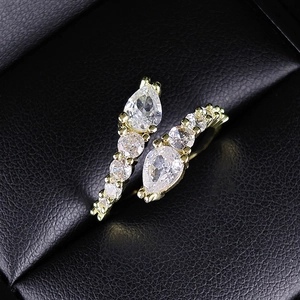 Macro shot of gold snake-style open ring featuring pear-cut zircon and crystal pavé details