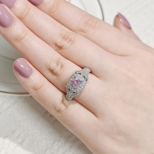 Detalle macro de anillo de plata con piedra central rosa redonda y pavé de circonitas