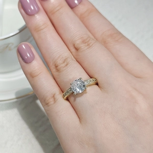 Detailed close-up of a gold solitaire ring with zircon and micro-pave setting on hand