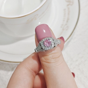 Primer plano de anillo de plata con circón rosa y detalles de diamantes en una taza