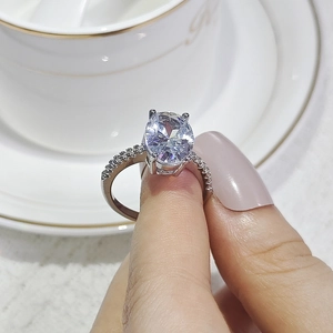 Detalle macro del anillo con circón ovalado, engaste de cuatro garras y pavé lateral