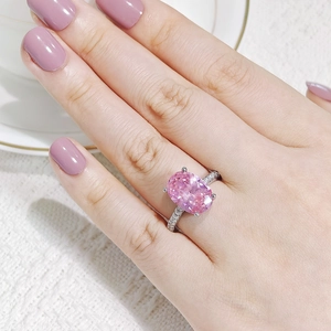 Primer plano de elegante anillo ovalado de circón rosa en mano con engaste de plata