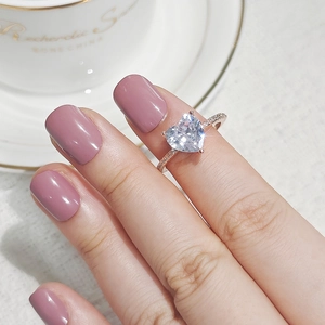 Nahaufnahme eines Zirkonia-Rings mit Herzschliff in Roségold an der Hand
