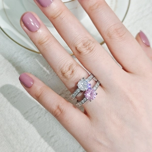 Close-up of stacked silver rings featuring round white and pink cubic zirconia gemstones