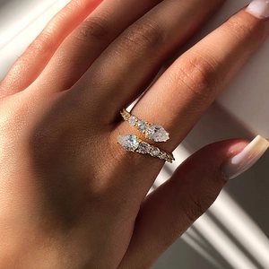 Elegant gold bypass ring with marquise and round cut zircons on a hand model