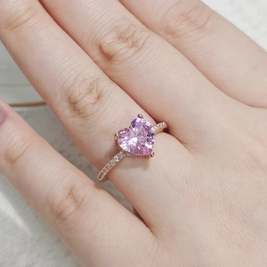 Nahaufnahme eines herzförmigen rosa Zirkonia-Rings mit roségoldenem Band und weißen Diamanten