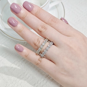 Close-up of stacked gold and silver eternity bands with clear cubic zirconia on finger