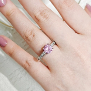 Close-up of pink zircon ring with micro-pave white diamonds on silver band