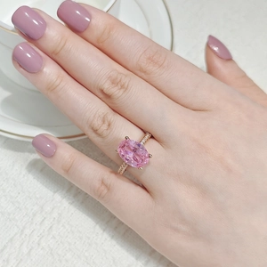 Detalle de anillo de circón rosa ovalado con pavé de diamantes en banda de oro rosa