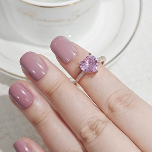 Nahaufnahme eines herzförmigen rosa Zirkonia-Rings mit roségoldenem Band und Besatz