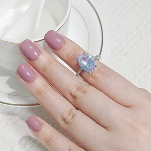 Primer plano de un anillo de plata de lujo con una gran gema azul ovalada en un dedo