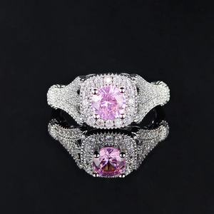 Anillo de plata de lujo con circón rosa central y halo de diamantes sobre espejo negro