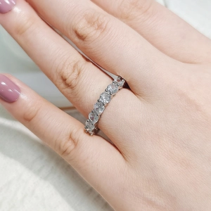 Detailed view of an elegant silver multi-stone ring worn on a finger with lavender nails