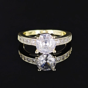 Exquisite gold zircon ring featuring a classic four-prong setting on a black mirror surface