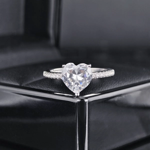 Nahaufnahme eines Herzschliff-Zirkonia-Rings mit Kristallen auf schwarzer Lederbox