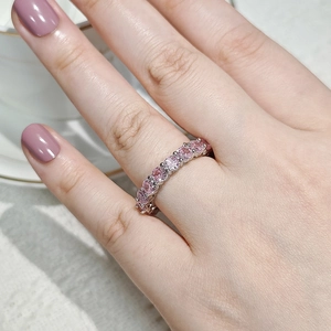 Macro shot of a sparkling silver ring with a row of pink round-cut cubic zirconia stones