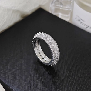 Macro view of multi-row silver pave ring with round zircons on black leather display