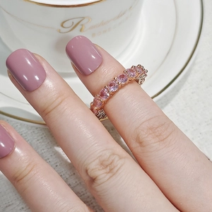 Macro shot of rose gold eternity band featuring sparkling round pink cubic zirconia stones